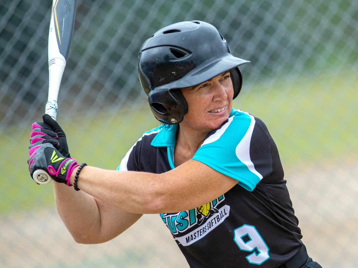 Masters woman hitting ball with baseball bat